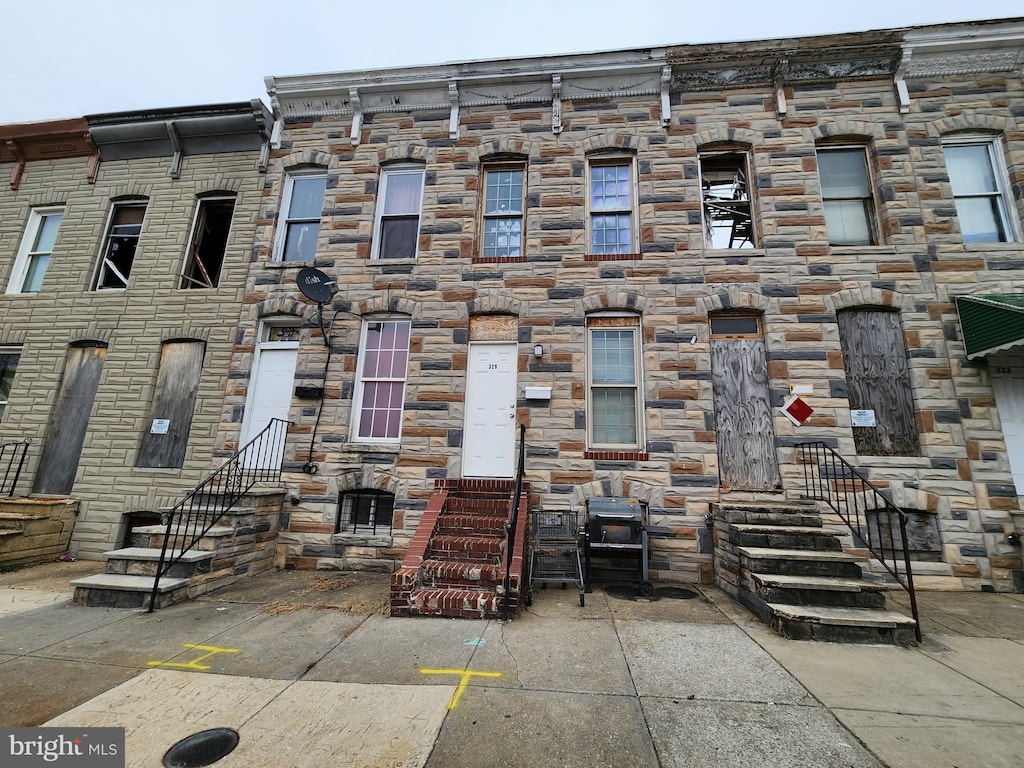 townhome / multi-family property with stone siding and entry steps