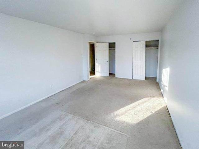 unfurnished bedroom with two closets