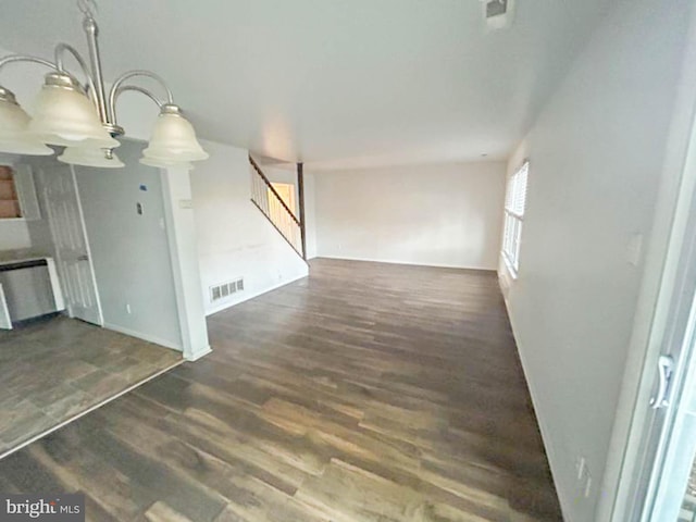 unfurnished living room featuring visible vents, wood finished floors, and stairs