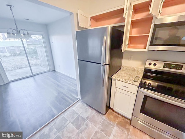 kitchen with light stone counters, white cabinets, stainless steel appliances, and open shelves