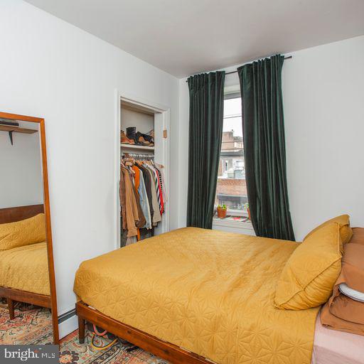 bedroom featuring a closet and a baseboard heating unit