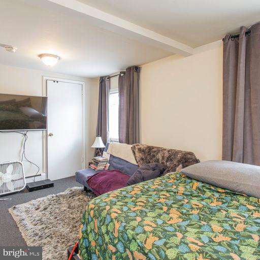 carpeted bedroom featuring beam ceiling