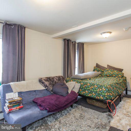 bedroom with beam ceiling and carpet