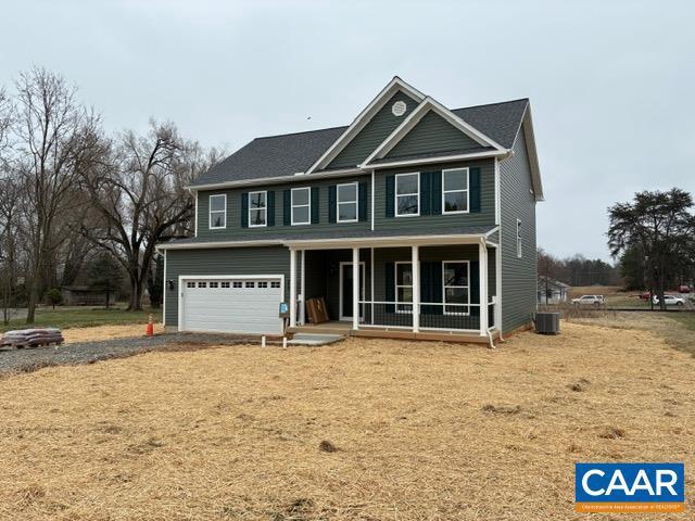 view of front of property with central AC, gravel driveway, and a garage