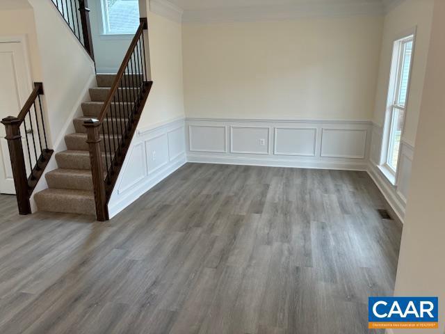 interior space with visible vents, wood finished floors, and crown molding