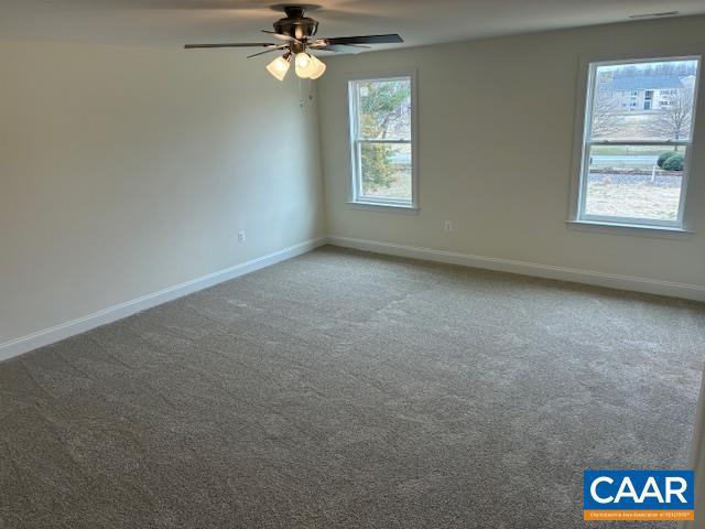 carpeted empty room with baseboards and ceiling fan