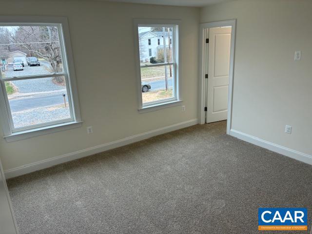 unfurnished room featuring baseboards and carpet