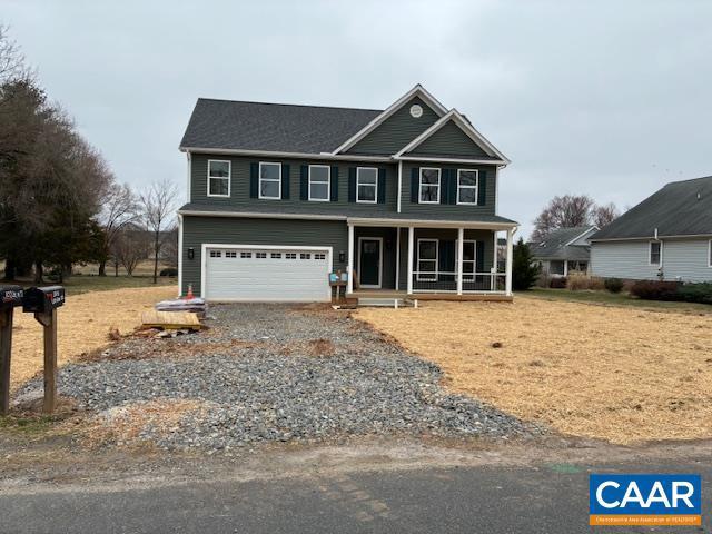 view of front facade with covered porch, driveway, and a garage