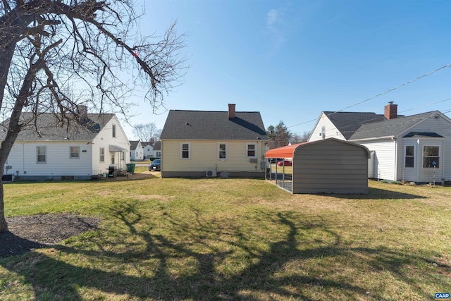 rear view of house featuring a lawn and a carport