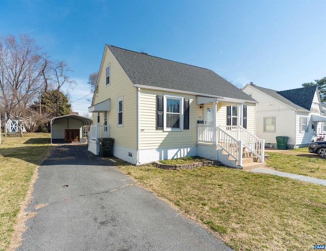 bungalow with a detached carport, a front yard, driveway, and crawl space