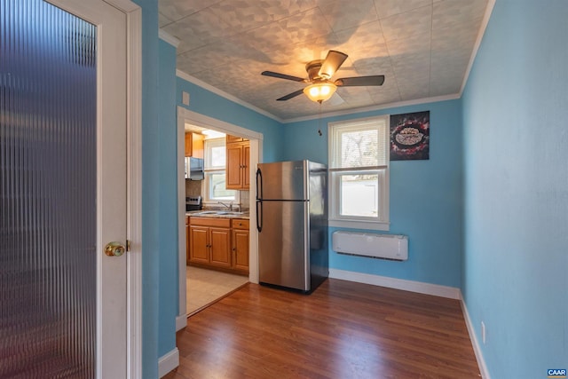 interior space with crown molding, plenty of natural light, and freestanding refrigerator