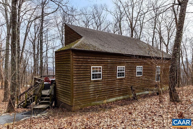 view of side of property featuring a shingled roof