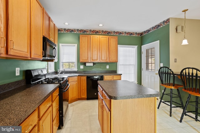 kitchen featuring recessed lighting, a sink, black appliances, dark countertops, and a center island