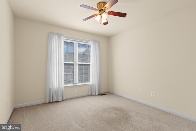 carpeted spare room featuring baseboards and ceiling fan