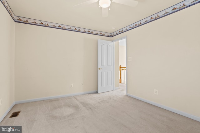 spare room featuring visible vents, baseboards, carpet, and a ceiling fan