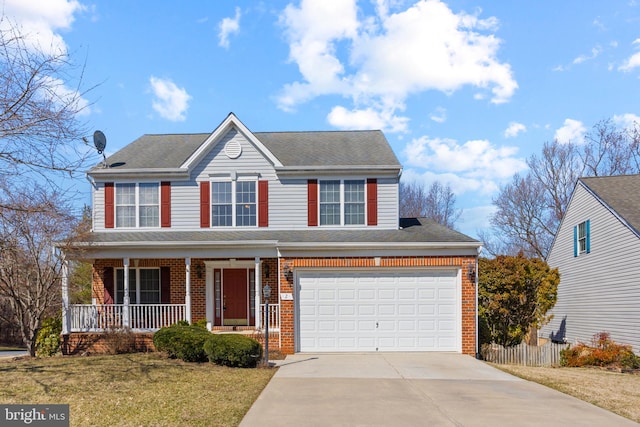 traditional-style home with brick siding, fence, a porch, a front yard, and driveway