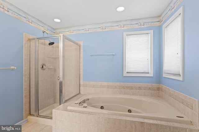 bathroom with tile patterned flooring, a tub with jets, and a stall shower