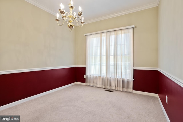 carpeted spare room with a chandelier, visible vents, crown molding, and baseboards