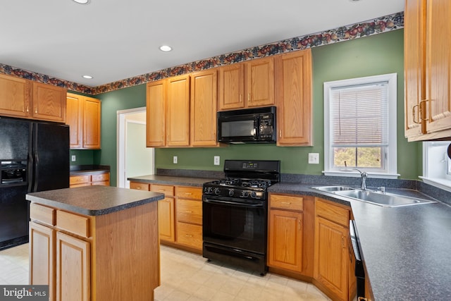 kitchen with black appliances, dark countertops, a kitchen island, and a sink