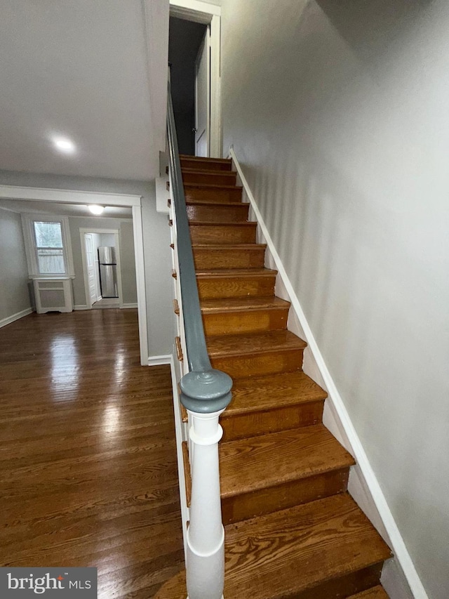 stairway with baseboards and wood finished floors