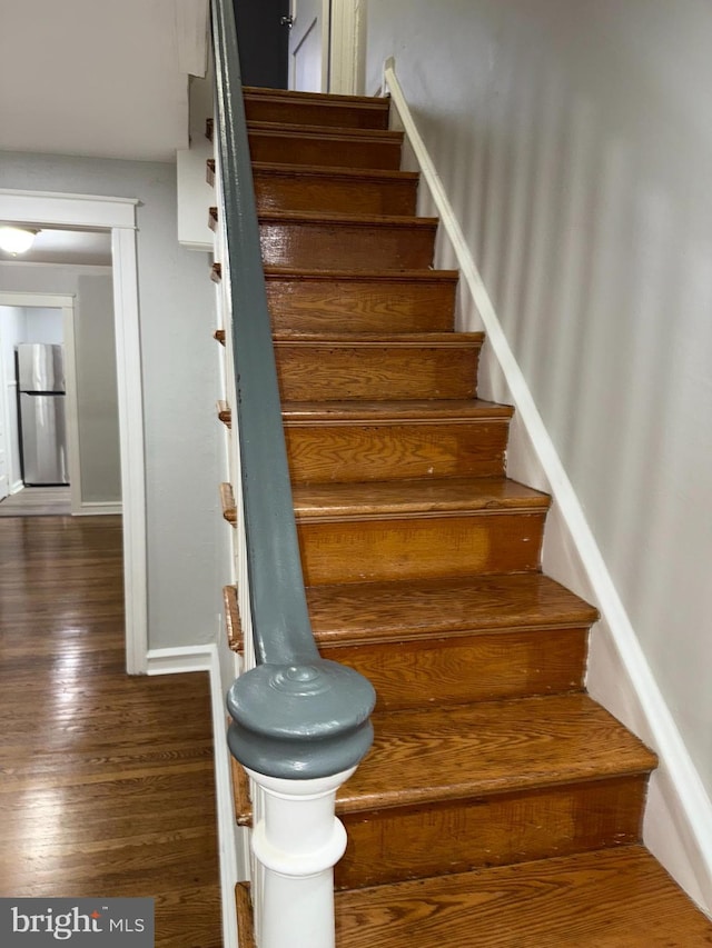 stairs with wood finished floors and baseboards