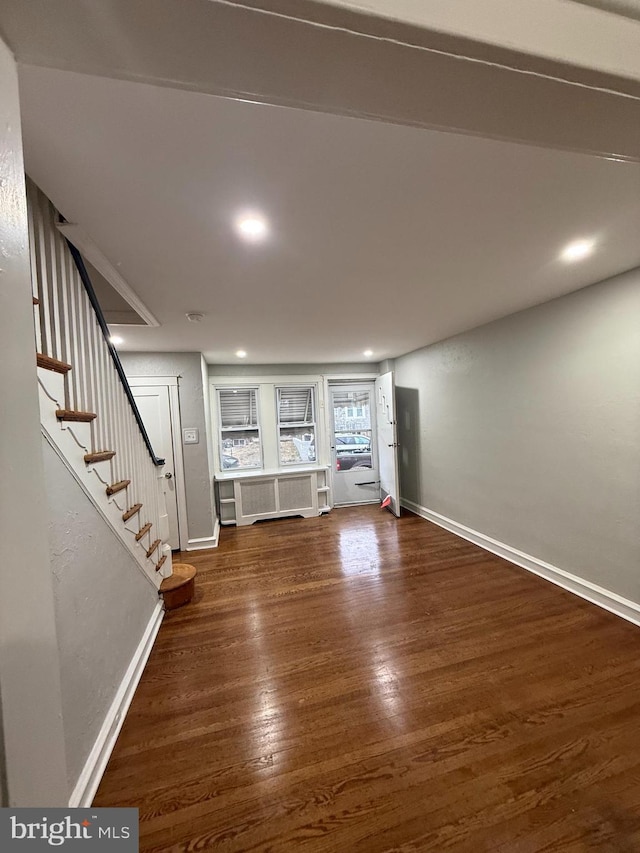 unfurnished living room featuring stairway, recessed lighting, wood finished floors, and baseboards