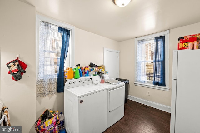 washroom with visible vents, independent washer and dryer, dark wood-style floors, baseboards, and laundry area