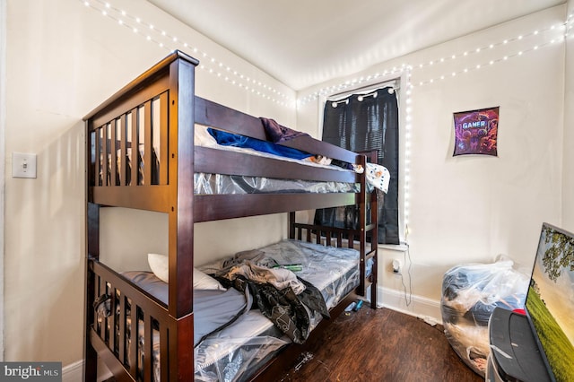 bedroom featuring baseboards and wood finished floors