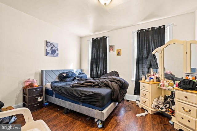 bedroom featuring baseboards and dark wood-style floors