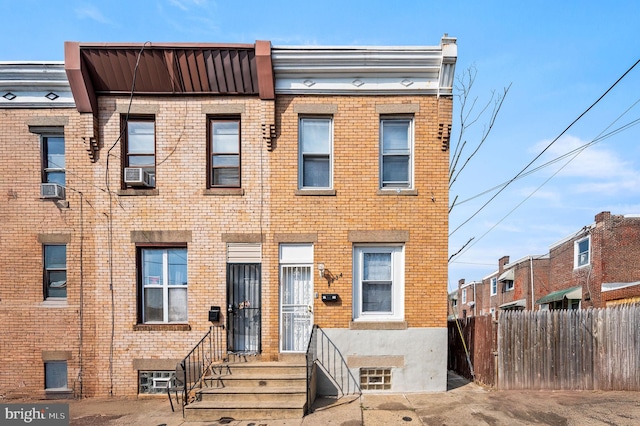 multi unit property with cooling unit, brick siding, and fence