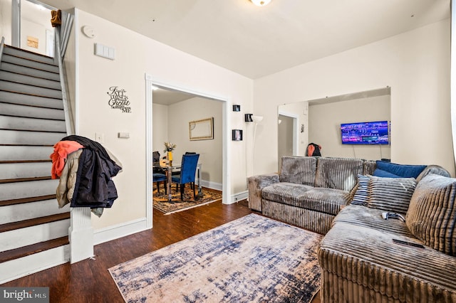 living area featuring stairs, baseboards, and wood finished floors