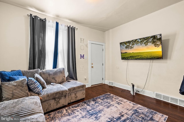 living room featuring wood finished floors, visible vents, and baseboards