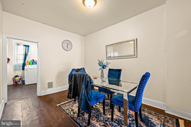 office space featuring visible vents, washer / clothes dryer, wood finished floors, and baseboards