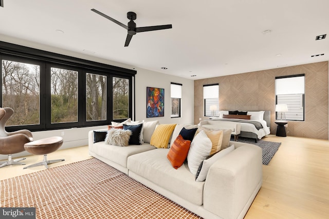 bedroom with wallpapered walls, wood finished floors, and ceiling fan