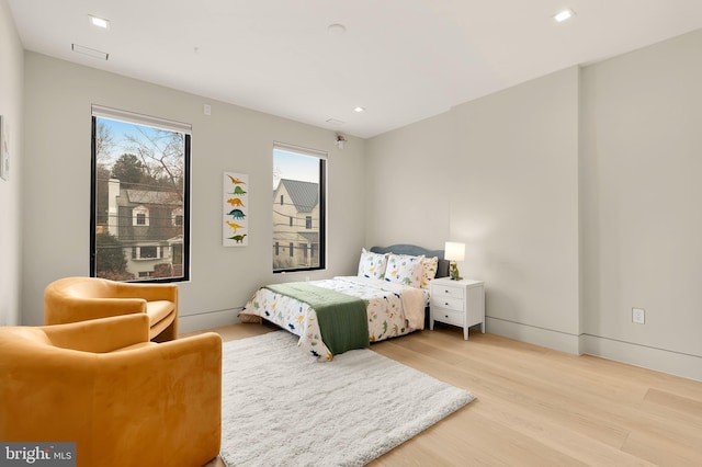 bedroom with recessed lighting, wood finished floors, and baseboards