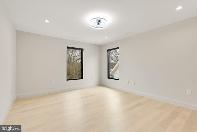 unfurnished room featuring recessed lighting, light wood-type flooring, and baseboards