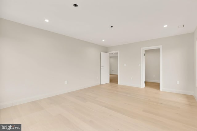 spare room with recessed lighting, light wood-type flooring, and baseboards