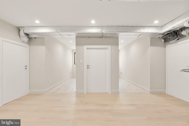 finished below grade area with baseboards and light wood-style floors