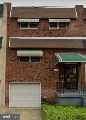view of front facade with concrete driveway, an attached garage, and brick siding