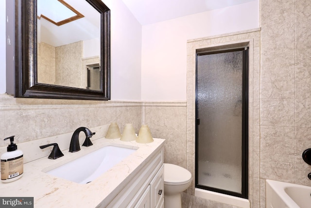 full bathroom with a wainscoted wall, a tub, tile walls, toilet, and a shower with door