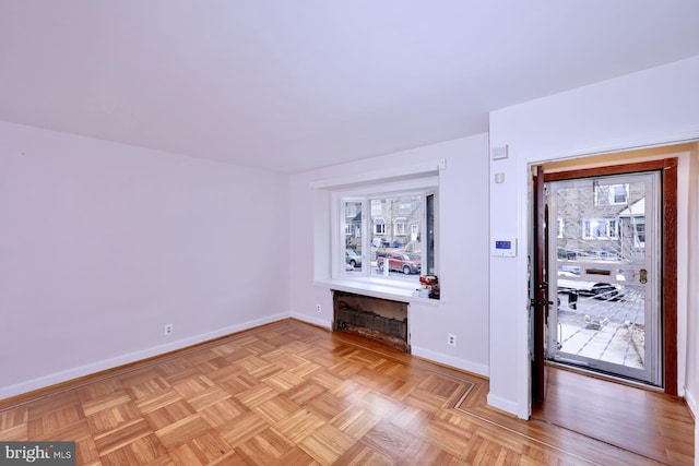 interior space featuring baseboards, a healthy amount of sunlight, and a fireplace