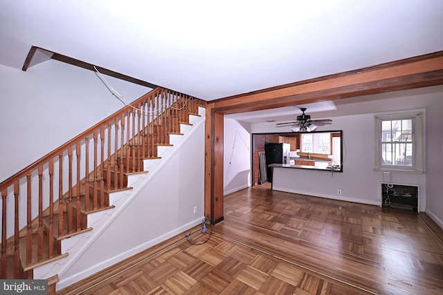 stairs featuring baseboards and a ceiling fan