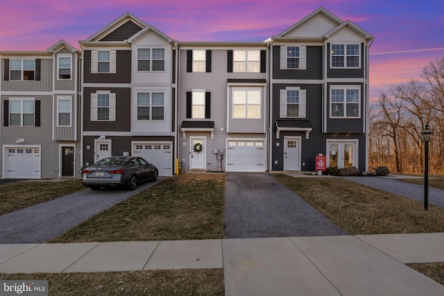 view of property with french doors, a garage, and driveway