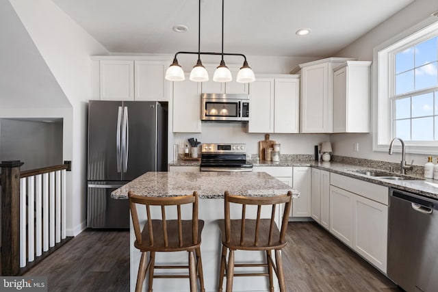 kitchen with a sink, dark wood-type flooring, appliances with stainless steel finishes, and white cabinetry