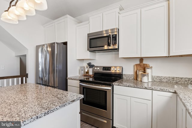 kitchen featuring stainless steel appliances, light stone countertops, and white cabinets