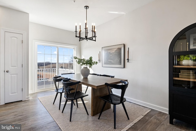 dining area with a chandelier, arched walkways, baseboards, and dark wood-style flooring