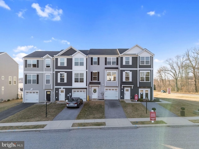 multi unit property featuring driveway and an attached garage