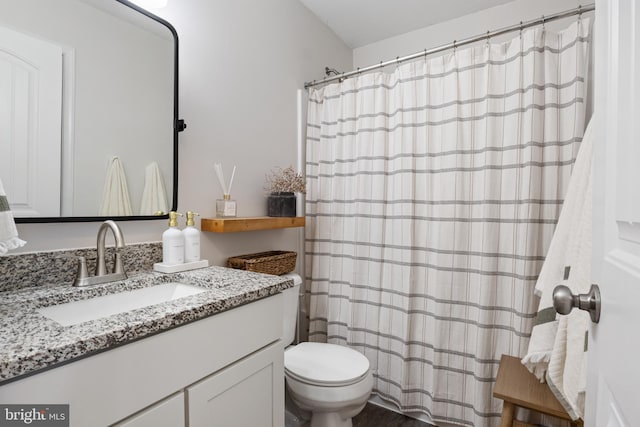 bathroom with toilet, vanity, and a shower with shower curtain