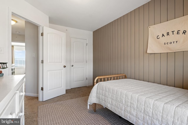 carpeted bedroom with wooden walls