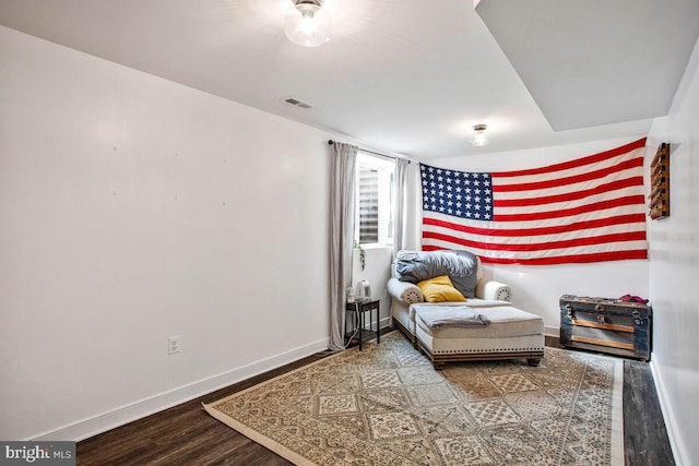 sitting room with visible vents, baseboards, and wood finished floors